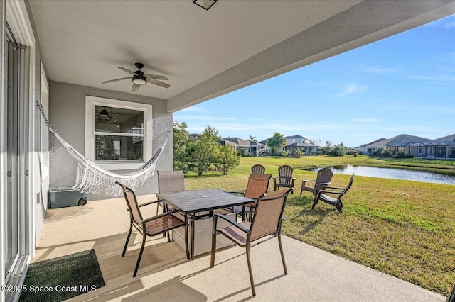 view of patio / terrace featuring ceiling fan and a water view