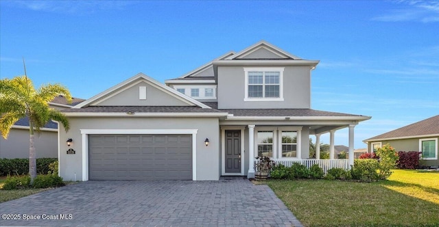 view of front of home featuring a porch, a garage, and a front lawn