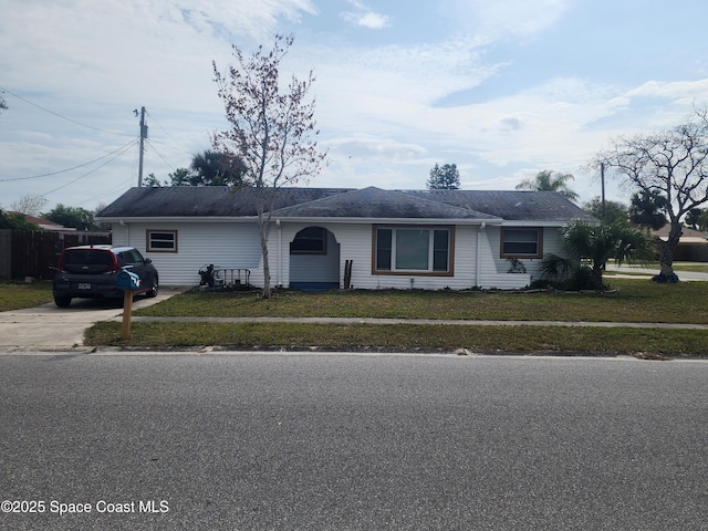 single story home featuring a front lawn, fence, and driveway