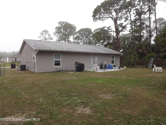 back of property featuring central AC, a lawn, and a patio area