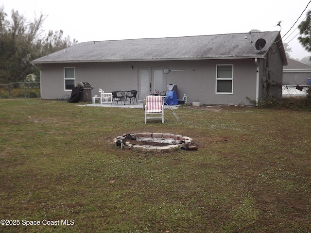 back of house with a yard, a patio area, and a fire pit