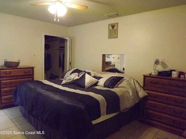 tiled bedroom featuring a spacious closet, a closet, and ceiling fan