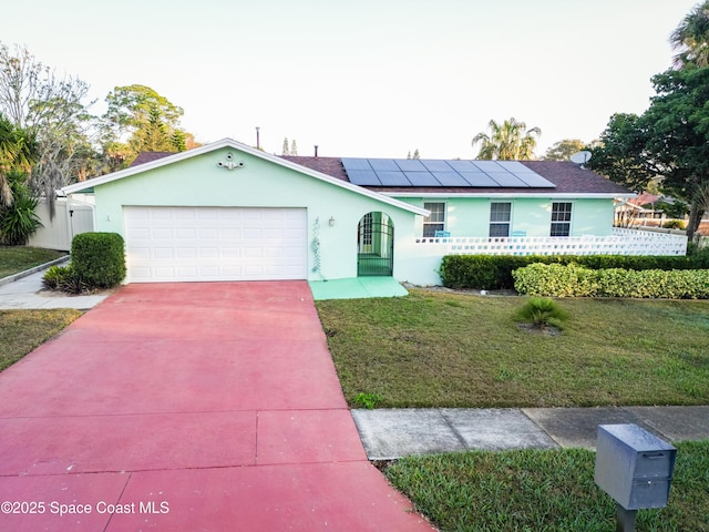 single story home featuring a garage, a front yard, and solar panels