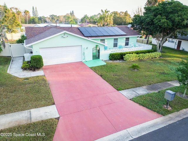 view of front facade with a garage, a front lawn, and solar panels