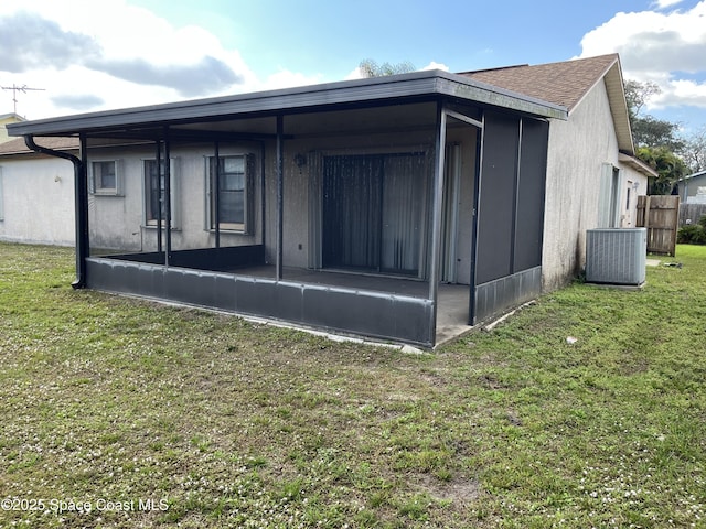 back of house with a sunroom, a yard, and cooling unit