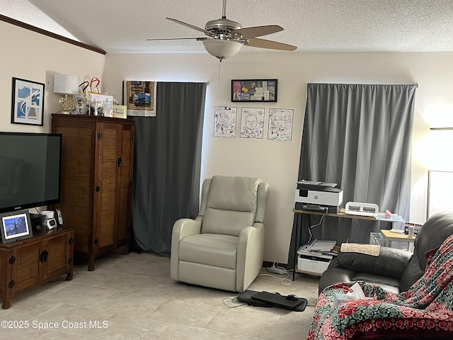 living room with ceiling fan and a textured ceiling