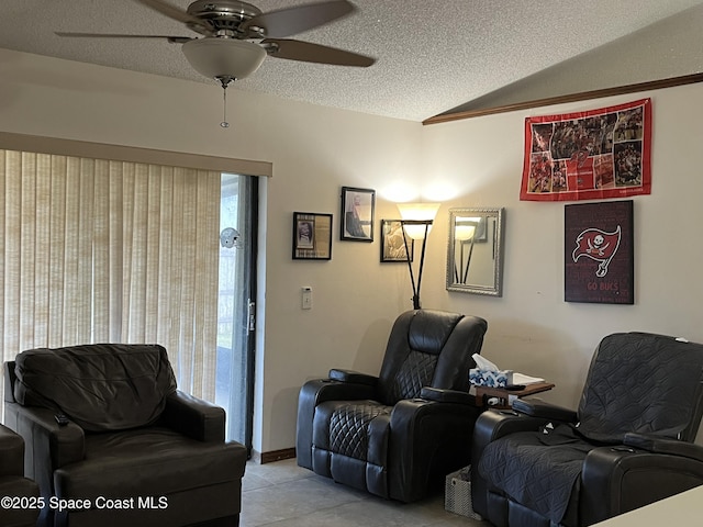 sitting room featuring ceiling fan, vaulted ceiling, and a textured ceiling