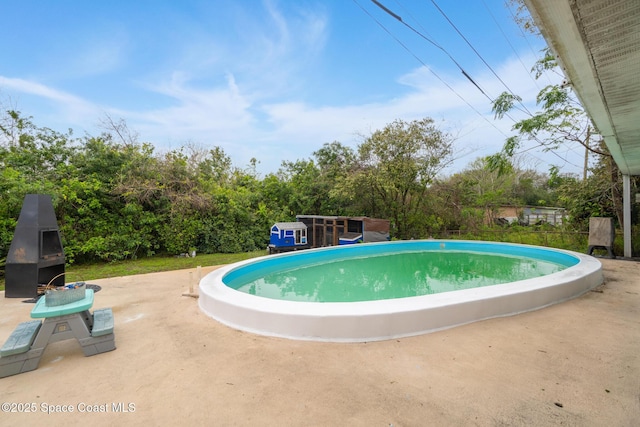 view of swimming pool with a patio area and a fireplace