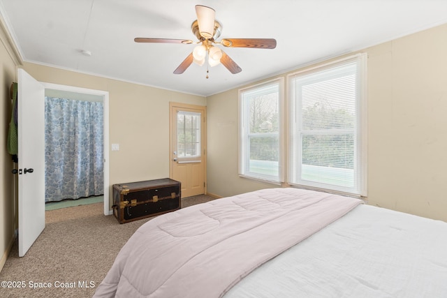 bedroom with light carpet, ceiling fan, multiple windows, and crown molding