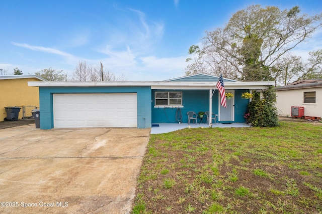 single story home with concrete driveway, concrete block siding, an attached garage, a porch, and a front yard