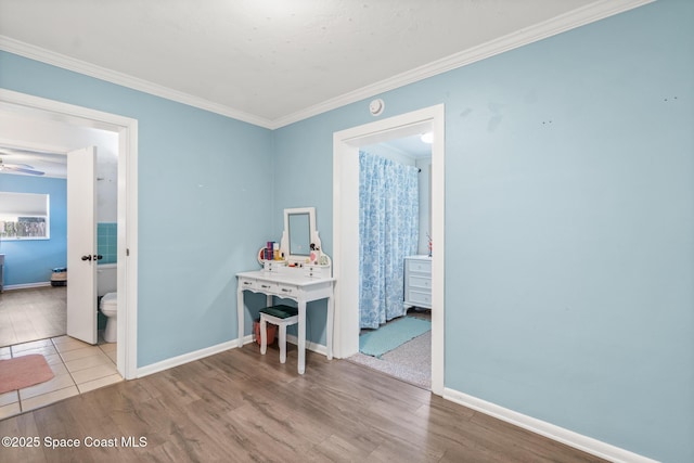 interior space featuring light wood-type flooring, crown molding, and baseboards