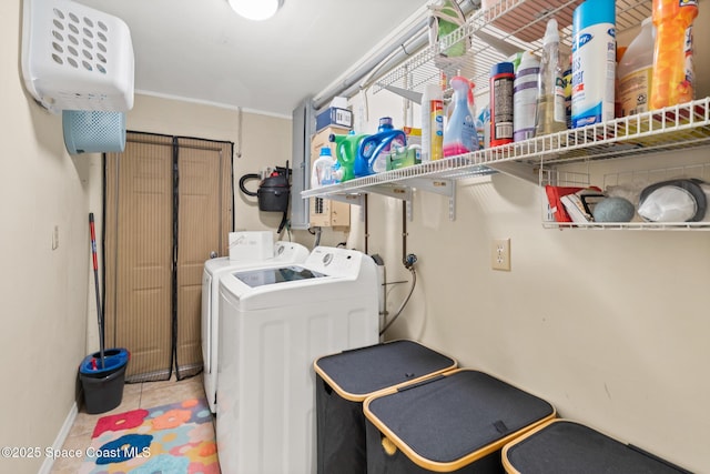 clothes washing area with laundry area, light tile patterned flooring, and washing machine and clothes dryer