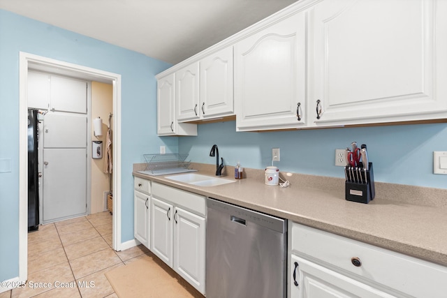 kitchen with light tile patterned floors, dishwasher, light countertops, white cabinetry, and a sink