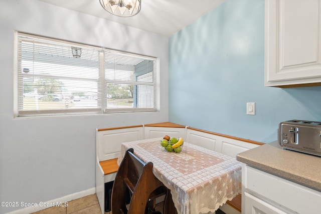 dining area featuring light tile patterned floors and a toaster