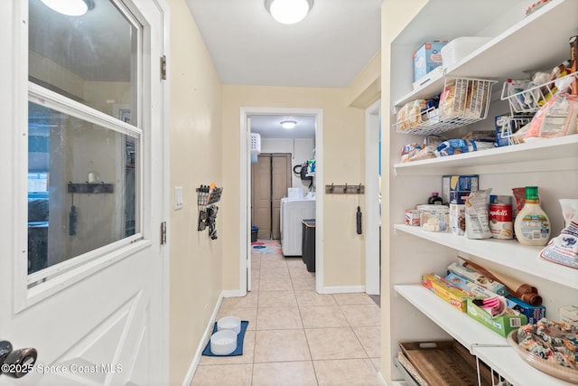 interior space featuring washer / clothes dryer, baseboards, and light tile patterned floors