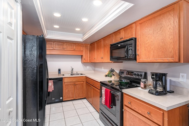 kitchen with black appliances, sink, ornamental molding, light tile patterned floors, and a tray ceiling