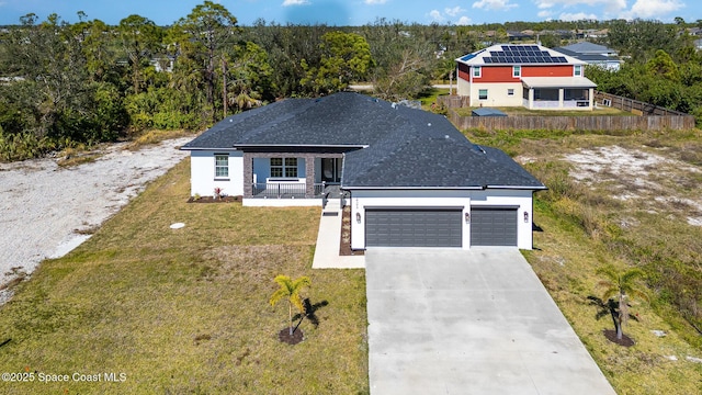 view of front of home featuring a garage, a porch, and a front yard