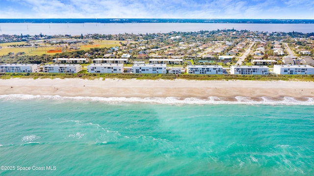 drone / aerial view with a water view and a beach view