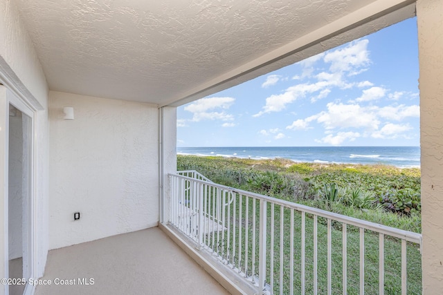 balcony featuring a beach view and a water view