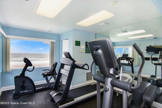 exercise room with a water view