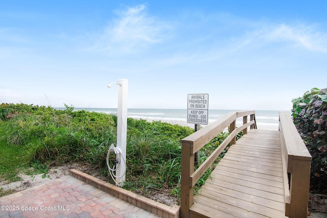 exterior space with a water view and a beach view