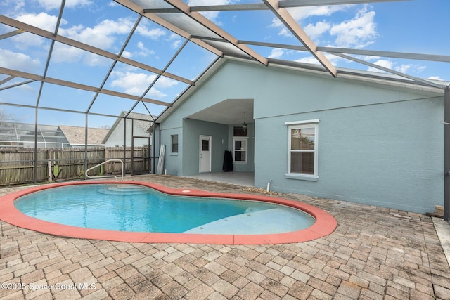 view of swimming pool featuring a patio and glass enclosure