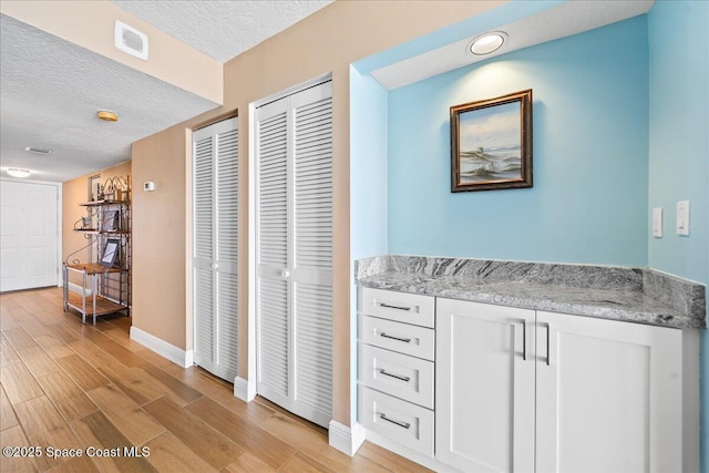 bathroom with hardwood / wood-style floors and a textured ceiling