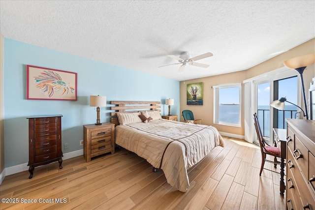 bedroom featuring ceiling fan, a textured ceiling, and light wood-type flooring