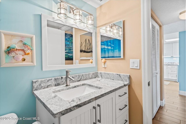 bathroom featuring vanity, hardwood / wood-style flooring, and toilet