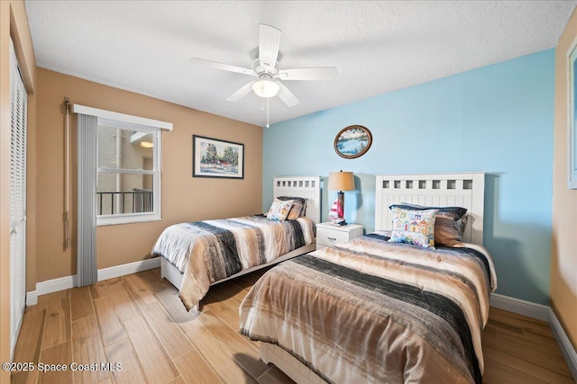 bedroom featuring ceiling fan, a textured ceiling, and light hardwood / wood-style floors