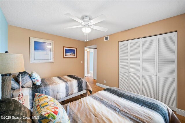 bedroom featuring ceiling fan, light hardwood / wood-style floors, and a closet