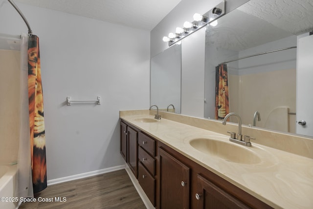 bathroom with vanity, hardwood / wood-style floors, a textured ceiling, and shower / tub combo with curtain