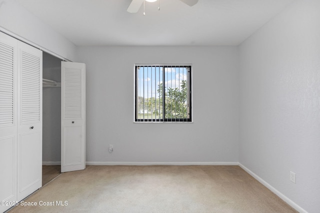 unfurnished bedroom featuring ceiling fan, a closet, and carpet