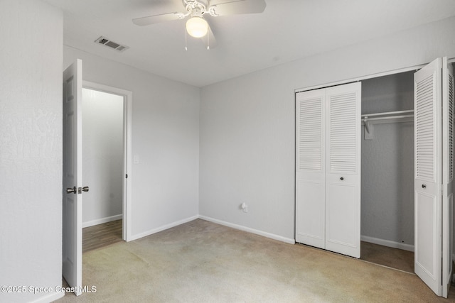 unfurnished bedroom featuring ceiling fan, light carpet, and a closet