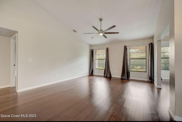 empty room featuring vaulted ceiling, dark hardwood / wood-style floors, and ceiling fan