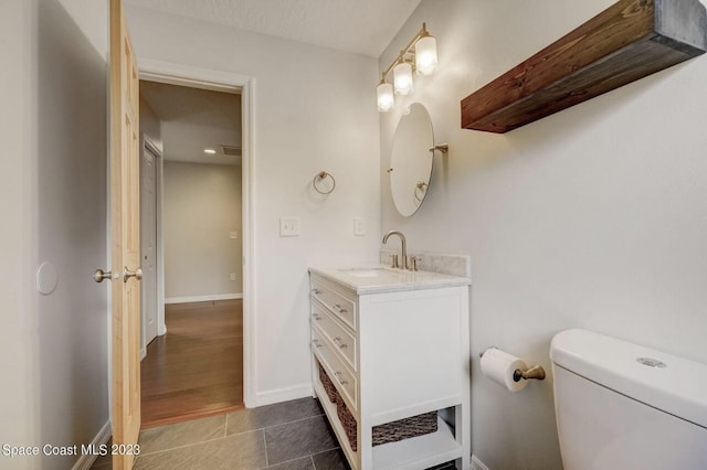 bathroom featuring vanity, tile patterned floors, and toilet