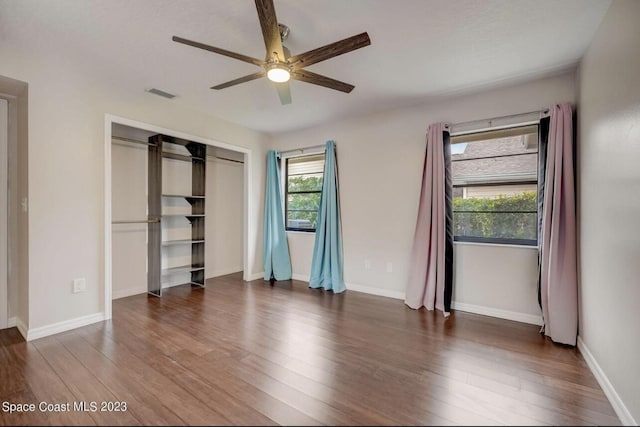 unfurnished bedroom with ceiling fan, dark hardwood / wood-style flooring, and a closet