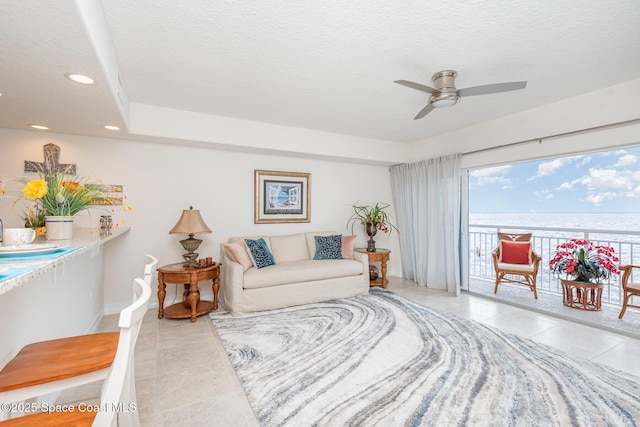 tiled living room with ceiling fan and a textured ceiling