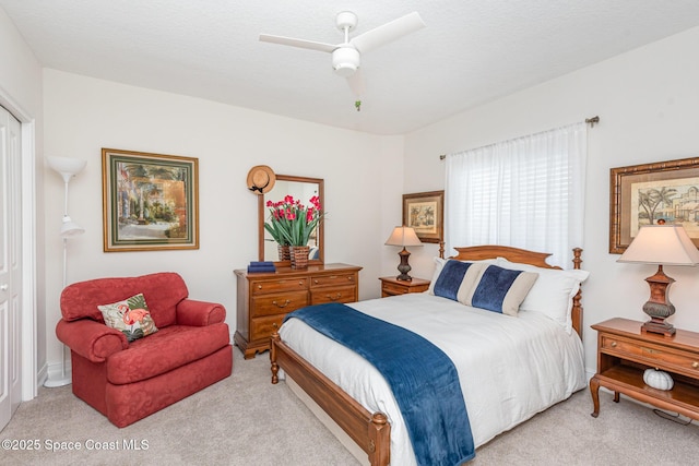 carpeted bedroom with a textured ceiling and ceiling fan