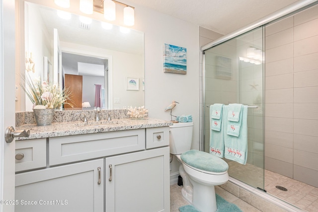 bathroom with vanity, toilet, and a shower with shower door