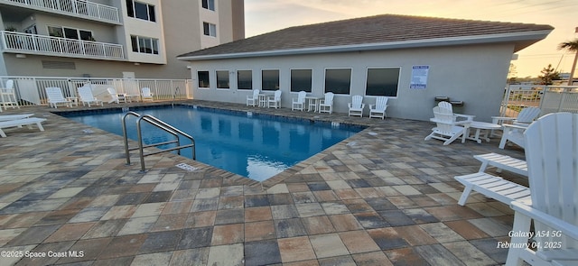 pool at dusk with a patio