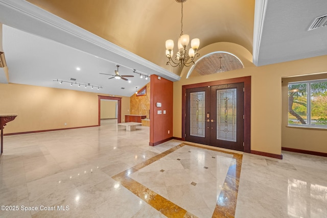 entryway featuring french doors, track lighting, lofted ceiling, and a chandelier