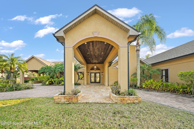 property entrance featuring a lawn and french doors