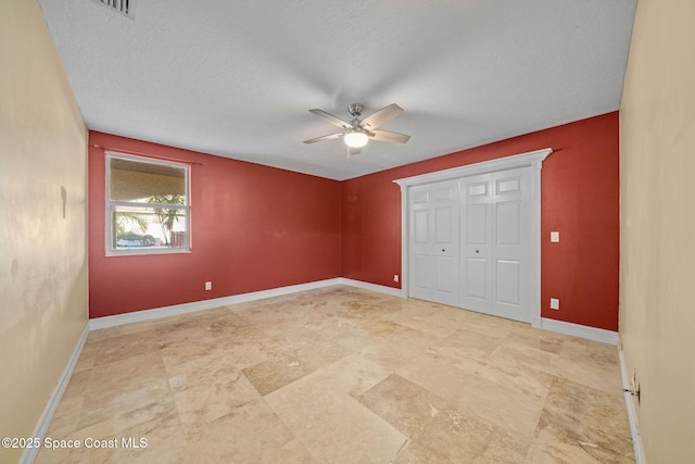 unfurnished bedroom featuring ceiling fan, a textured ceiling, and a closet