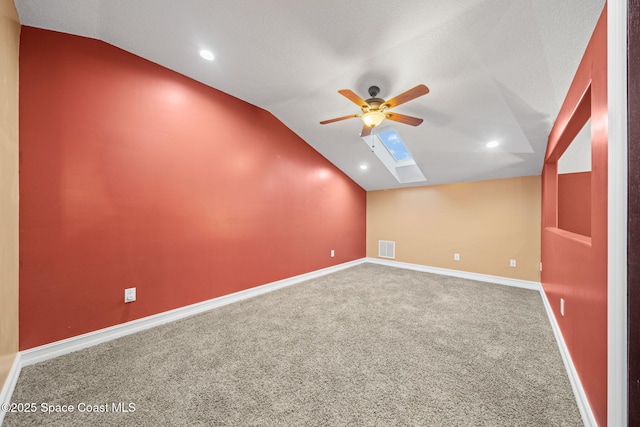 bonus room featuring carpet floors, lofted ceiling with skylight, and ceiling fan