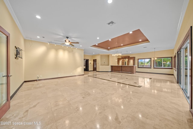 unfurnished living room with ornamental molding, ceiling fan, and a tray ceiling