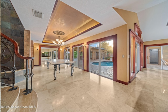 rec room featuring an inviting chandelier and a tray ceiling