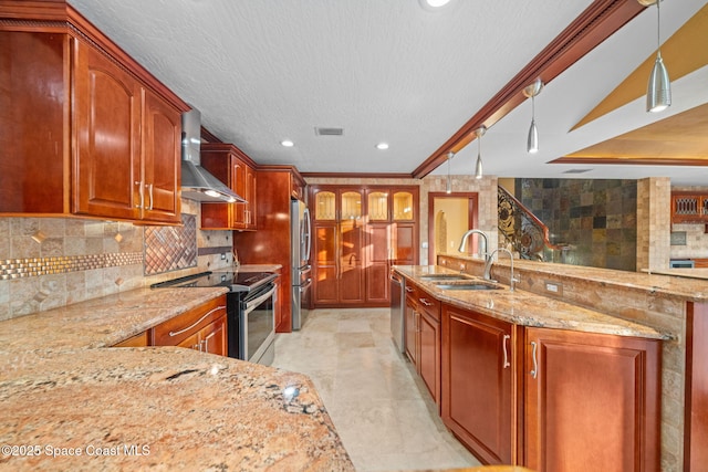 kitchen with appliances with stainless steel finishes, sink, backsplash, hanging light fixtures, and wall chimney range hood