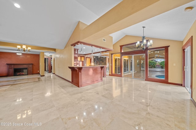 kitchen with high vaulted ceiling, a breakfast bar, a chandelier, and decorative light fixtures