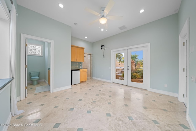 unfurnished living room with ceiling fan and french doors